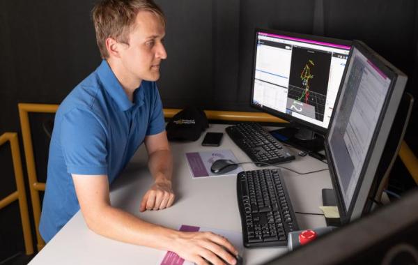 Pawel Golyski uses a computer to operate the CAREN system during an experiment.  