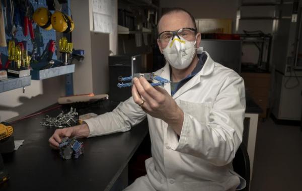 Dan Goldman holds smart active particle robot