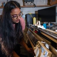 Former Matsumoto Group member Krishma Singal operates a knitting machine used to create fabric samples for a previous study. Singal recently graduated from Georgia Tech with her Ph.D. (Photo Credit: Allison Carter)